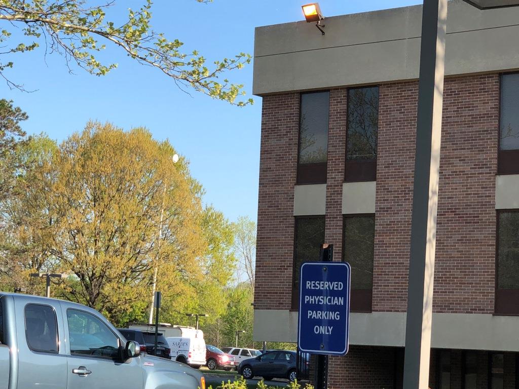 The van is seen, with mast fully extended, in a hospital parking lot.