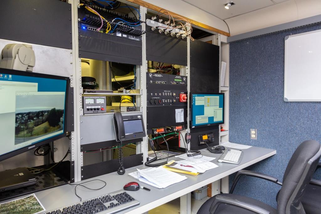 A view of the operating position with a variety of radios, computers, and other equipment visible.